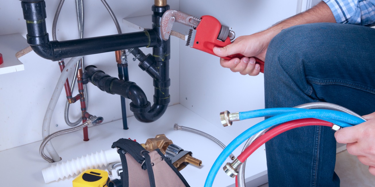 Plumber with Plumbing tools on the kitchen brick township nj